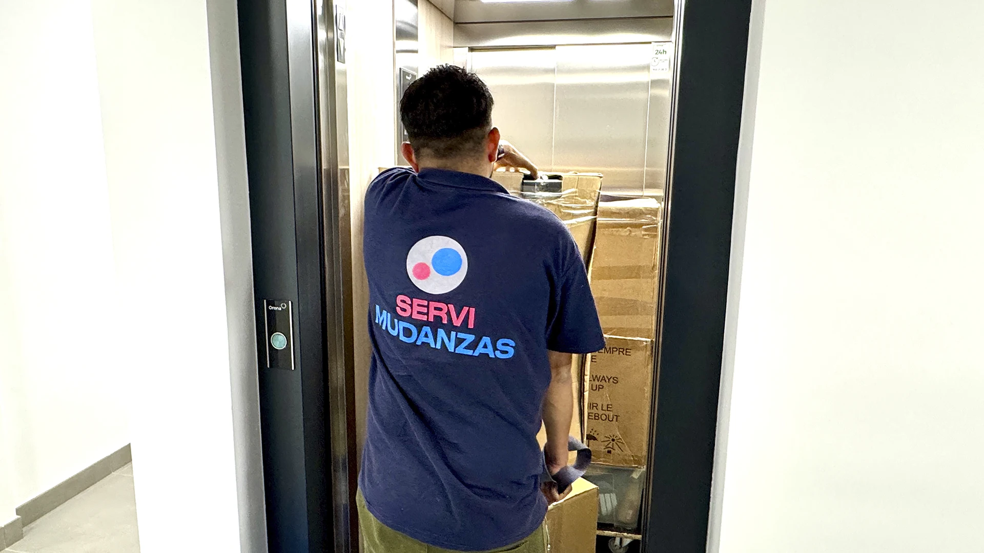 Operario en ascensor con cajas
